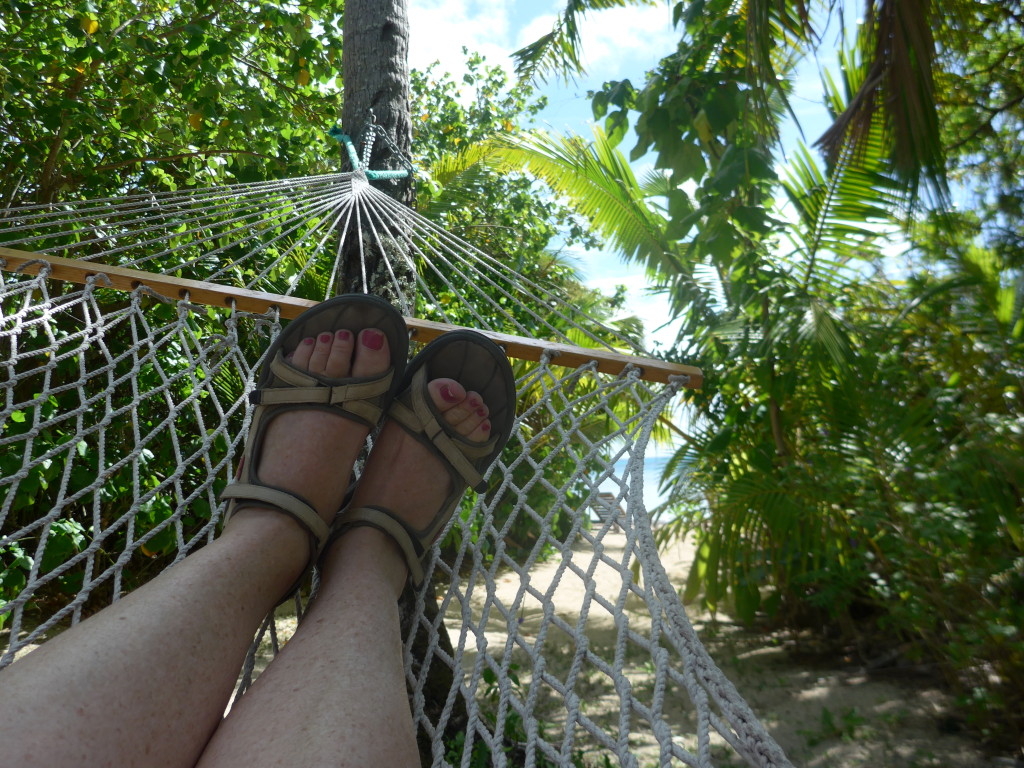 Sūsana relaxing in the hammock with the beach just through the trees.